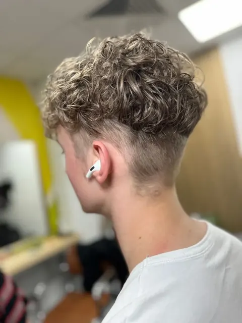 Curly haircut with short back and sides